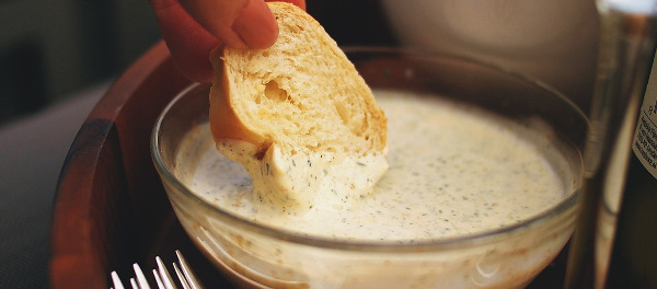 Pain trempé dans une tasse de mayonnaise